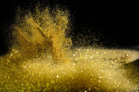 Photo for Explosion metallic gold glitter sparkle. Golden Glitter powder spark blink celebrate, blur foil explode in air, fly throw gold glitters particle. Black background isolated, selective focus Blur bokeh - Royalty Free Image
