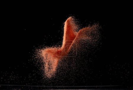 Photo for Red Sand flying explosion, particle dot grain wave explode. Abstract cloud fly. orange dried soil colored sand splash throwing in Air. Black background Isolated - Royalty Free Image