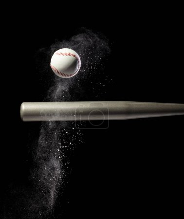 Foto de El jugador de béisbol golpeó la pelota con bate de plata y tierra de arena explotan en el aire. Jugadores de béisbol en acción dinámica golpearon cola de humo de bola. Fondo negro acción de congelación aislada - Imagen libre de derechos