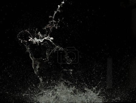 Foto de Lanzamiento de salpicaduras de agua en el ataque de agua gota revoloteando en el suelo de la pared y detener el movimiento de disparo de congelación. Splash Agua para explosión textura elementos de recursos gráficos, fondo negro aislado - Imagen libre de derechos