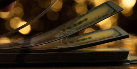 Flipping through stack of 100 US dollars bills, Counting cash and bend curve dollar bills with dream gold bokeh background. Dollar bills filling counting currency money cash