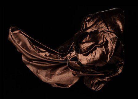 Téléchargez les photos : Tissu velours marron volant en forme de courbe, morceau de tissu Tissu velours marron jeter tomber dans l'air. Fond noir flou de mouvement isolé - en image libre de droit