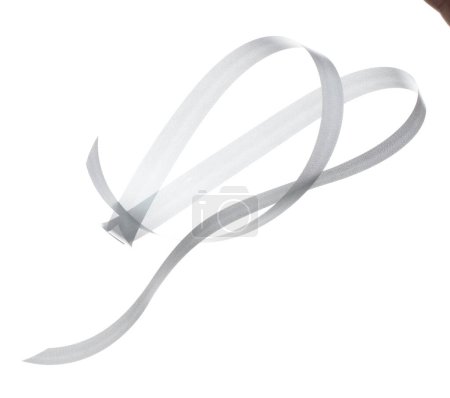 Photo for Gray ribbon long straight fly in air with curve roll shiny. Gray ribbon for present gift birthday party to wrap around decorate and make of textile cloth long straight. White background isolated - Royalty Free Image