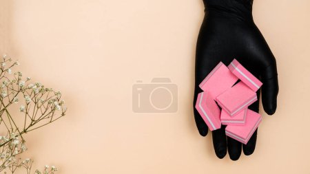 Foto de Un conjunto de limas de manicura con el mismo abrasivo en la mano del maestro de manicura resaltado sobre un fondo claro. Espacio de copia. - Imagen libre de derechos