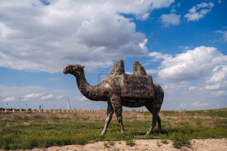 metal sculpture of a camel outdoors against a blue sky background