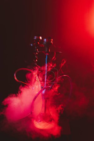 Téléchargez les photos : Narguilé moderne, shisha sur fond noir fumé avec éclairage au néon - en image libre de droit