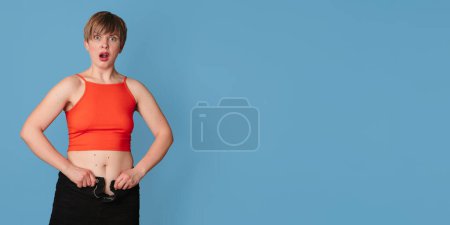 Portrait of an overweight woman, on which clothes do not fit, on a colored background. The concept of a healthy body, body positive. Panoramic banner. Copying the space