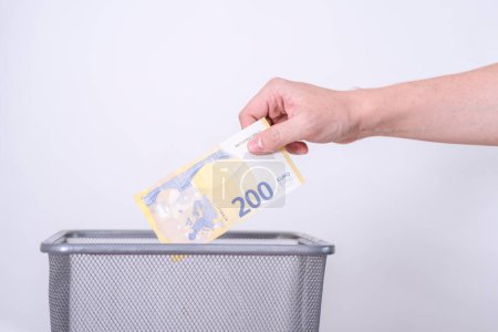 Photo for The hand throws two hundred euros in the trash. The concept of the devaluation of the euro. - Royalty Free Image