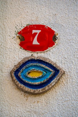 Photo for A sign with the number 7 in red on a white wall. The concept of architecture and construction. - Royalty Free Image