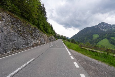 uphill road with long perspective along forest with scenic mountain view, Jaunpass, Canton Fribourg, Switzerland