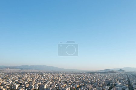 Foto de Una vista panorámica de Atenas, mostrando la vasta expansión urbana contra un telón de fondo de montañas bajo un cielo despejado - Imagen libre de derechos