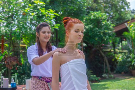 Téléchargez les photos : Jeune belle femme bénéficiant de massage dans le jardin tropical. - en image libre de droit