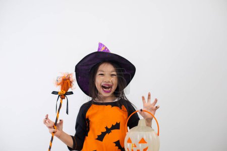 Foto de Niña divertida en traje de bruja para Halloween con calabaza y escoba de bruja. - Imagen libre de derechos