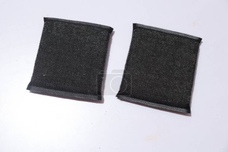 Foto de Nueva esponja negra absorbente aislada sobre un fondo blanco. Esponjas de cocina negro. - Imagen libre de derechos
