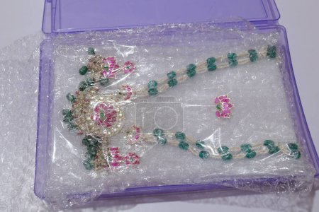 Téléchargez les photos : Perles artificielles de chaîne en pierre fabriquées à la main isolées sur fond blanc - en image libre de droit