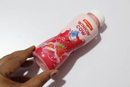 Téléchargez les photos : Main tenant bouteille de boisson laiteuse avec saveur de fraise - en image libre de droit