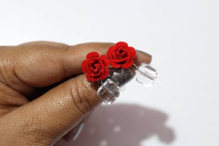 Téléchargez les photos : Boucles d'oreilles main avec fleurs rouges et pierres transparentes - en image libre de droit
