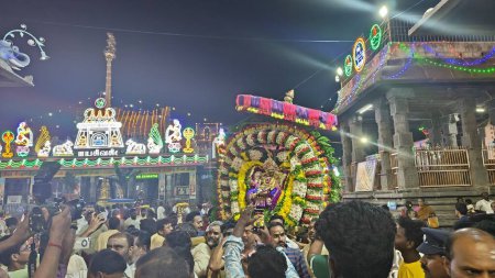 Téléchargez les photos : Vue de nuit des personnes adorant l'idole sacrée de Dieu hindou décorée avec une guirlande florale, Arunachalesvara Swamy Temple Karthika Deepam Festival à Thiruvannamalai au Tamil Nadu, Inde - en image libre de droit