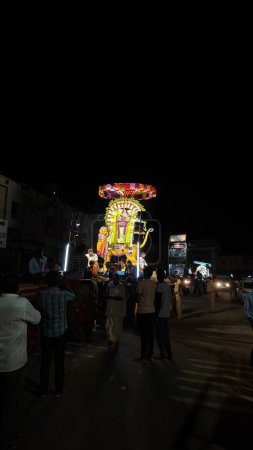 Téléchargez les photos : Vue de nuit des personnes adorant l'idole sacrée de Dieu hindou décorée avec une guirlande florale, Arunachalesvara Swamy Temple Karthika Deepam Festival à Thiruvannamalai au Tamil Nadu, Inde - en image libre de droit