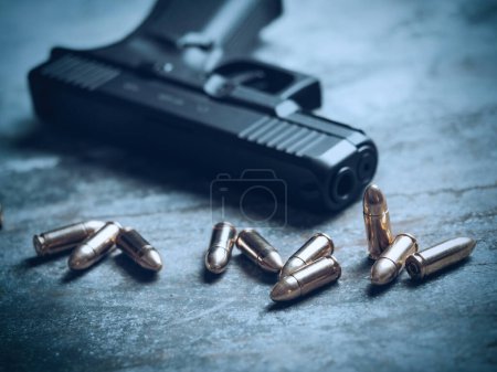 Photo for Hand gun with ammunition on dark background. 9 mm pistol military weapon and pile of bullets ammo at the metal table. - Royalty Free Image