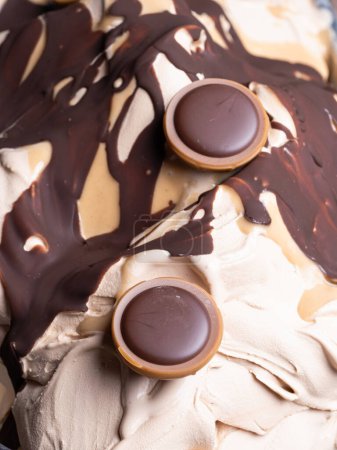 Frozen Toffifee flavour gelato - Vollständiges Rahmendetail. Nahaufnahme von beige cremiger Oberflächentextur von Eis mit Karamell und Schokoladenbelag mit Bonbons.