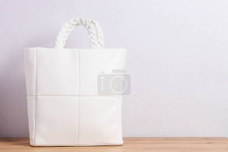 Foto de Bolso shopper de cuero blanco con asas trenzadas sobre fondo neutro - Imagen libre de derechos