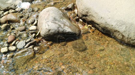 Photo for Close-up water flows through a river with different sized stones in it, rocky river - Royalty Free Image