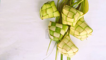 Bolsas de Ketupat sobre fondo blanco - Ketupat es un tipo de bola de masa hervida hecha de arroz envasada dentro de un contenedor en forma de diamante de una bolsa de hojas de palma tejida, comida tradicional musulmana durante la celebración de Eid al-Fitr