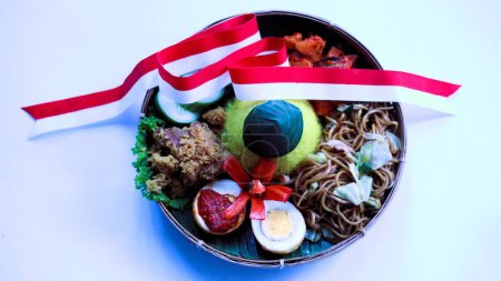 Tumpeng merah putih, yellow cone shaped rice decorated with red and white ribbon served during Indonesia independence day celebration on August 17, white background