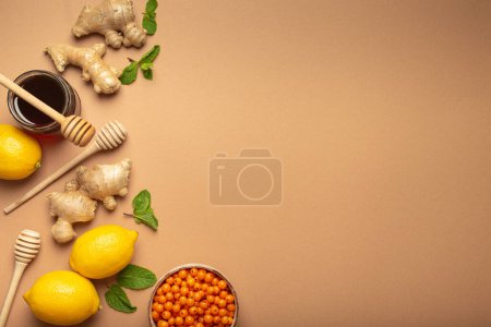Photo for Lemons, mint, ginger, sea buckthorn berries, honey in glass jar, honey wooden dippers top view. Food for immunity stimulation and against flu. Healthy remedies to boost immune system, copy space. - Royalty Free Image
