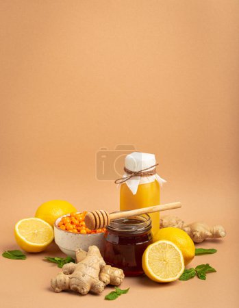 Photo for Composition with detox drink, sea buckthorn berries, lemons, mint, ginger, honey in glass jar. Food for immunity stimulation and against flu. Healthy natural remedies to boost immune system. - Royalty Free Image