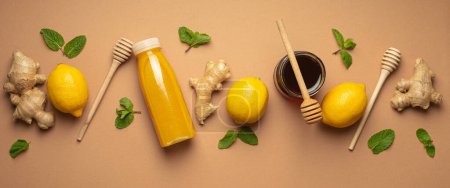 Photo for Composition with detox drink, lemons, mint, ginger, honey in glass jar, honey wooden dippers top view. Food for immunity stimulation and against flu. Healthy natural remedies to boost immune system. - Royalty Free Image