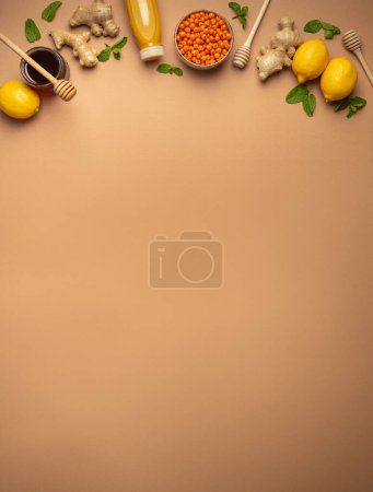 Photo for Lemons, mint, ginger, sea buckthorn berries, honey in glass jar, orange drink in bottle top view. Food for immunity stimulation and against flu. Healthy remedies to boost immune system, copy space. - Royalty Free Image