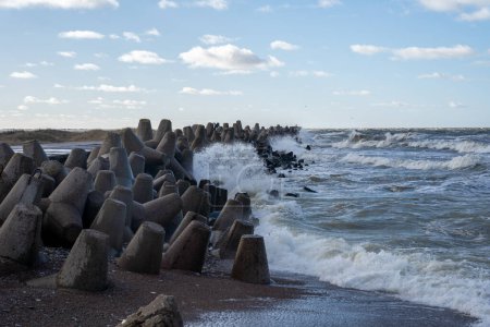 Photo for Waves crashing against breakwater consisting of gray concrete tetrapods. Liepaja, Latvia. Liepjas Ziemelu mols - Royalty Free Image