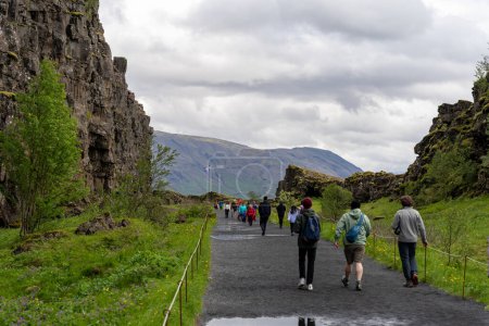 Foto de Thingvellir rift valley, Islandia - 06.26.2023: Turistas caminando en la grieta continental entre las placas tectónicas de América del Norte y Eurasia en Islandia - Imagen libre de derechos