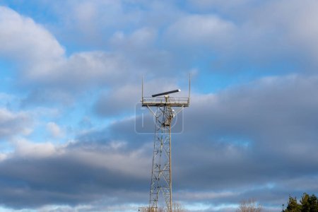 Foto de Torre con sistema de radar de vigilancia costera y varios equipos de comunicación. Nublado cielo azul de fondo - Imagen libre de derechos
