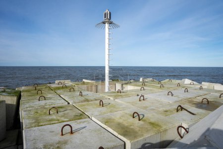 Photo for Light beacon on breakwater made of large square concrete blocks - Royalty Free Image