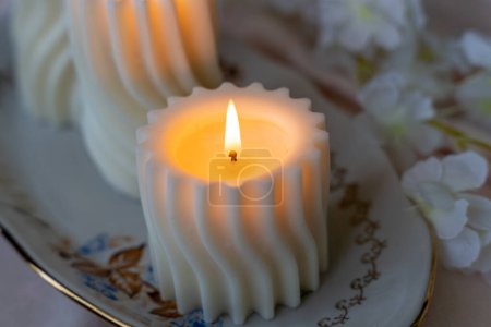 Lit spiral swirl pattern white soy wax candle