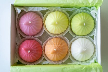 Velas de cera de soja coloridas en forma de Zefir en una caja