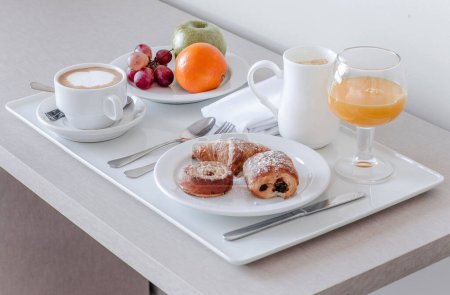 Photo for A continental breakfast setup with pastries, coffee, and fresh fruit - Royalty Free Image