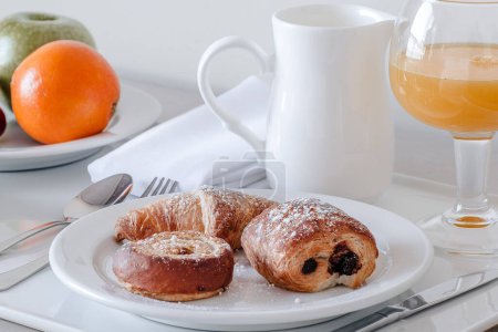 Photo for Freshly baked pastries served with orange juice and fruit for breakfast - Royalty Free Image