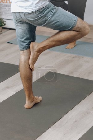 Man doing a quad stretch on a yoga mat