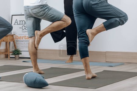 Two people practicing partner stretching exercises in a studio.