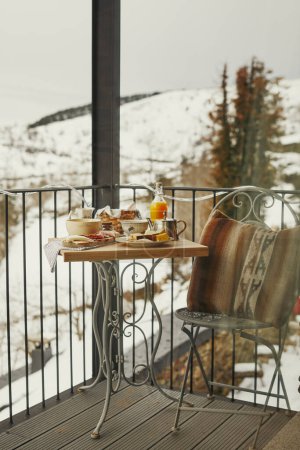 Intimate balcony brunch with a view of winter nature.