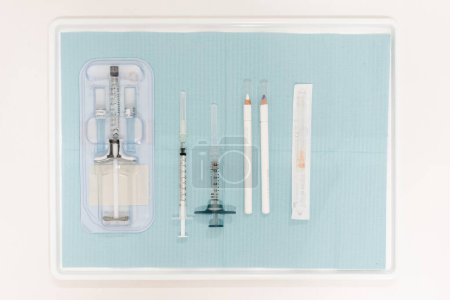 Doctor's tray with an acid vial and various aesthetic medical tools, showcasing professional skincare preparations