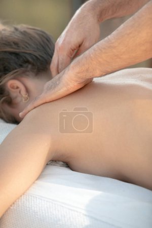 Téléchargez les photos : Massage professionnel du cou profond : mains focalisées appliquant une pression sur la zone cervicale du client féminin pour soulager la tension - en image libre de droit
