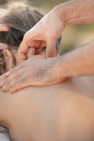 Téléchargez les photos : Massage ciblé du cou et des épaules. Vue détaillée de la main d'un thérapeute soulageant la tension musculaire chez la cliente - en image libre de droit