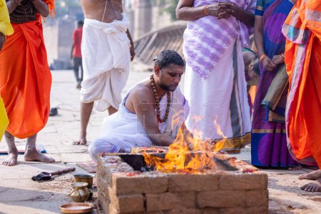 Téléchargez les photos : Varanasi, Uttar Pradesh, India - November 2022: Unidentified brahmin male performing shraadh rituals on ghat near ganges in varanasi. Varanasi is oldest city in India with rich culture and diversity. - en image libre de droit