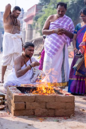 Téléchargez les photos : Varanasi, Uttar Pradesh, India - November 2022: Unidentified brahmin male performing shraadh rituals on ghat near ganges in varanasi. Varanasi is oldest city in India with rich culture and diversity. - en image libre de droit