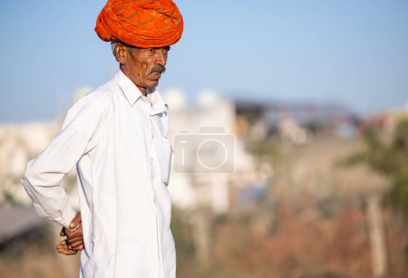 Foto de Pushkar, Rajasthan, India - November 2022: Pushkar Fair, camel trader in ethnic dress at fair ground during pushkar fair. - Imagen libre de derechos